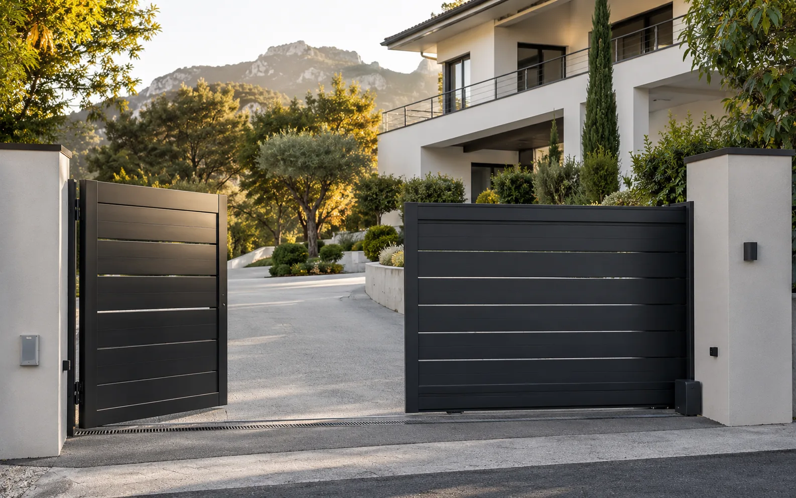 Portail battant et coulissant anthracite devant une maison avec terrain en pente